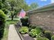 Lush landscaping frames the home, complemented by a brick exterior and a visible American flag at 8206 Bull Run Ct, Indianapolis, IN 46227