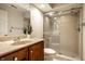 Tiled bathroom featuring cherry vanity and updated glass-doored shower at 8690 Jaffa Ct W Dr # 28, Indianapolis, IN 46260