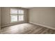 Bright bedroom featuring hardwood floors and natural light from a window with modern blinds at 8690 Jaffa Ct W Dr # 28, Indianapolis, IN 46260