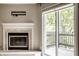 Living room featuring a cozy fireplace and a sliding glass door to a deck offering natural light at 8690 Jaffa Ct W Dr # 28, Indianapolis, IN 46260