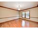 Sunlit room with hardwood floors, trim and a large window overlooking backyard at 9158 Oak Knoll Ln, Fishers, IN 46037