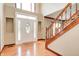 Bright foyer featuring hardwood floors, staircase with wooden banister, and ornate front door at 9158 Oak Knoll Ln, Fishers, IN 46037
