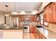 Updated kitchen featuring stainless steel appliances, wooden cabinets, and granite countertops at 9158 Oak Knoll Ln, Fishers, IN 46037