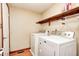 Bright laundry room features modern washer and dryer, wood floors, and storage shelves at 9158 Oak Knoll Ln, Fishers, IN 46037