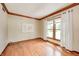 Living room with hardwood floors, large window, and decorative molding at 9158 Oak Knoll Ln, Fishers, IN 46037