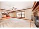 Spacious living room featuring a brick fireplace, carpeting, and connection to an open-concept kitchen at 9158 Oak Knoll Ln, Fishers, IN 46037