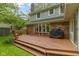 Wooden back deck with brick house facade, built in bench, and grill at 974 Arrowwood Dr, Carmel, IN 46033