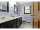 Bathroom featuring a double sink vanity with black cabinetry and wood framed mirror at 974 Arrowwood Dr, Carmel, IN 46033