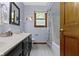 Bathroom with a double sink vanity, shower with curtain, and wood framed mirror at 974 Arrowwood Dr, Carmel, IN 46033