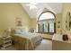 The cozy bedroom has a large arched window, neutral walls, and is complemented by a ceiling fan at 974 Arrowwood Dr, Carmel, IN 46033