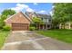 Traditional brick home with an attached two-car garage and a spacious driveway at 974 Arrowwood Dr, Carmel, IN 46033