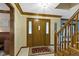 Elegant foyer featuring a grand wood door, tile flooring, and staircase detail at 974 Arrowwood Dr, Carmel, IN 46033