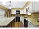 Updated kitchen with granite countertops, black appliances, white cabinetry, and a stylish center island at 974 Arrowwood Dr, Carmel, IN 46033