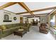 Open living room with beamed ceilings, comfortable seating, and seamless transition to kitchen at 974 Arrowwood Dr, Carmel, IN 46033