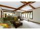 Large living room featuring beamed ceilings, comfortable sectional, and backyard view at 974 Arrowwood Dr, Carmel, IN 46033