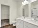 Bathroom featuring double sinks, white cabinets, and walk-in closet at 104 Maxim Ct, Cumberland, IN 46229