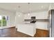 Well-lit kitchen boasts a center island, stainless steel appliances, and modern white cabinetry at 104 Maxim Ct, Cumberland, IN 46229
