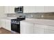 Kitchen showing stainless steel oven, range, microwave, white countertop, and stylish backsplash at 104 Maxim Ct, Cumberland, IN 46229