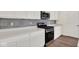 Modern kitchen with stainless steel appliances, stylish backsplash, and white cabinetry at 104 Maxim Ct, Cumberland, IN 46229
