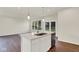 Bright kitchen includes a center island with a sink, dishwasher, and dark wood flooring at 104 Maxim Ct, Cumberland, IN 46229