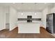 Bright kitchen features an island, stainless steel appliances, white cabinets and sleek countertops at 104 Maxim Ct, Cumberland, IN 46229