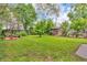 Home showcasing a generous backyard with grassy areas and privacy provided by mature trees and fencing at 1124 S Lockburn St, Indianapolis, IN 46241