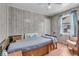 Serene bedroom featuring wood-paneled walls, natural light, and cozy furnishings at 1124 S Lockburn St, Indianapolis, IN 46241