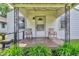 Inviting front porch with seating, lush greenery, and a view of the charming home's entrance at 1124 S Lockburn St, Indianapolis, IN 46241