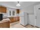 Traditional kitchen features wooden cabinets, white appliances, and a bright window with natural light at 1124 S Lockburn St, Indianapolis, IN 46241