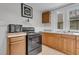 Practical kitchen with cabinets, stove, and window; vintage charm meets functionality in design at 1124 S Lockburn St, Indianapolis, IN 46241