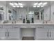Well-lit bathroom featuring double sinks, vanity and a mounted television at 1130 Deerbrook Trl, Greenwood, IN 46142