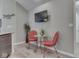 Inviting dining area featuring red metal chairs, glass-top table, and a mounted television for casual dining at 1130 Deerbrook Trl, Greenwood, IN 46142