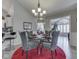 Elegant dining room featuring a glass-top table set for four, with a modern chandelier and neutral decor at 1130 Deerbrook Trl, Greenwood, IN 46142