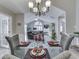 Tasteful dining room with glass table, place settings, and views into the bright sunroom and living area at 1130 Deerbrook Trl, Greenwood, IN 46142