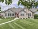 Beautifully landscaped home with stone accents, trimmed lawn, and an inviting walkway at 1130 Deerbrook Trl, Greenwood, IN 46142