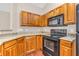 An updated kitchen featuring granite counters, wood cabinets, and modern appliances at 1139 Fernwood Way, Plainfield, IN 46168
