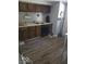 Functional kitchen featuring wooden cabinets, laminate floors, and essential appliances for meal preparation at 1212 River Heights Dr, Indianapolis, IN 46240