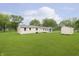Large backyard featuring a shed, patio, and a house with light yellow siding surrounded by mature trees at 125 S Alfonte St, Ingalls, IN 46048