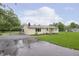 Quaint yellow home with a covered parking area showcasing a lush green lawn at 125 S Alfonte St, Ingalls, IN 46048