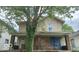 Two-story home with a covered front porch and tree in yard at 127 S Belmont Ave, Indianapolis, IN 46222