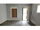 The living room has graffiti and damage with a partially boarded-up window at 127 S Belmont Ave, Indianapolis, IN 46222
