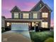 Beautiful two-story home boasting brick and gray siding, with well-manicured lawn under a colorful sunset sky at 1381 Avocet Dr, Greenwood, IN 46143