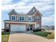 Inviting two-story home with brick and gray siding, showcasing a spacious driveway and manicured front lawn at 1381 Avocet Dr, Greenwood, IN 46143