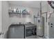 Functional laundry room with washer, dryer, and shelf storage for cleaning supplies at 1381 Avocet Dr, Greenwood, IN 46143