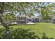 Mature trees shade the home's backyard, which includes a wooden deck and green lawn at 1480 E Jefferson St, Franklin, IN 46131