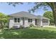 Beautifully landscaped front yard with a gray brick home, lush lawn, and mature trees offering shade and curb appeal at 1480 E Jefferson St, Franklin, IN 46131