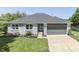 Inviting gray brick home with lush green lawn, manicured landscaping, and gray two-car garage at 1480 E Jefferson St, Franklin, IN 46131