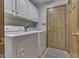 Well-equipped laundry room with washer, dryer, storage cabinets, and exterior access at 1480 E Jefferson St, Franklin, IN 46131