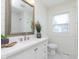 Bright bathroom with shiplap walls, decorative mirror and neutral color palette at 1502 Burdsal Pkwy, Indianapolis, IN 46208