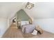 Charming bedroom with slanted ceilings, complemented by a decorative light fixture and ample natural light at 1502 Burdsal Pkwy, Indianapolis, IN 46208